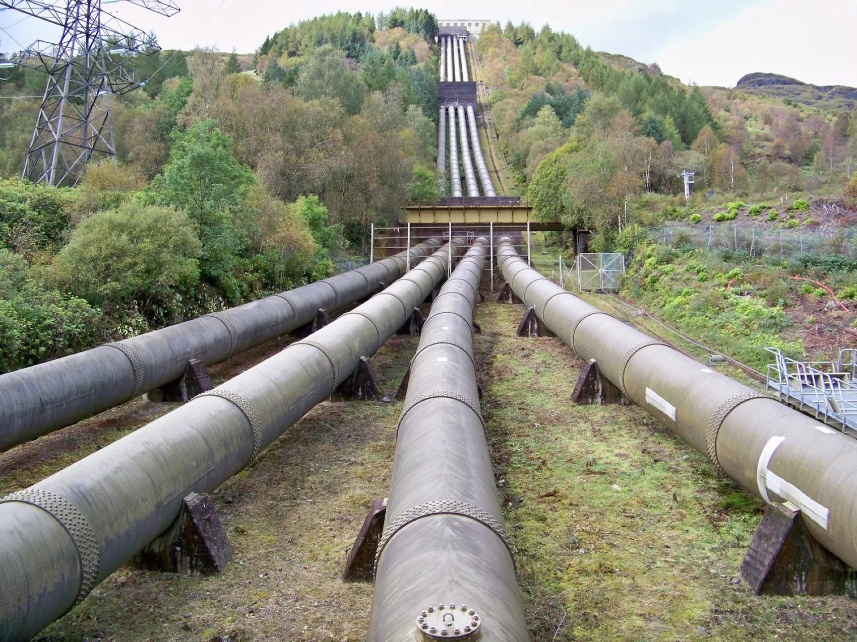 Steel penstocks running up a hillside to a hydroelectric power station